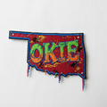 Embroidered iron-on patch in the shape of Oklahoma with OKIE in retro rocker letters