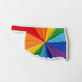 Embroidered iron-on patch in the shape of Oklahoma filled with vibrant rainbow colors